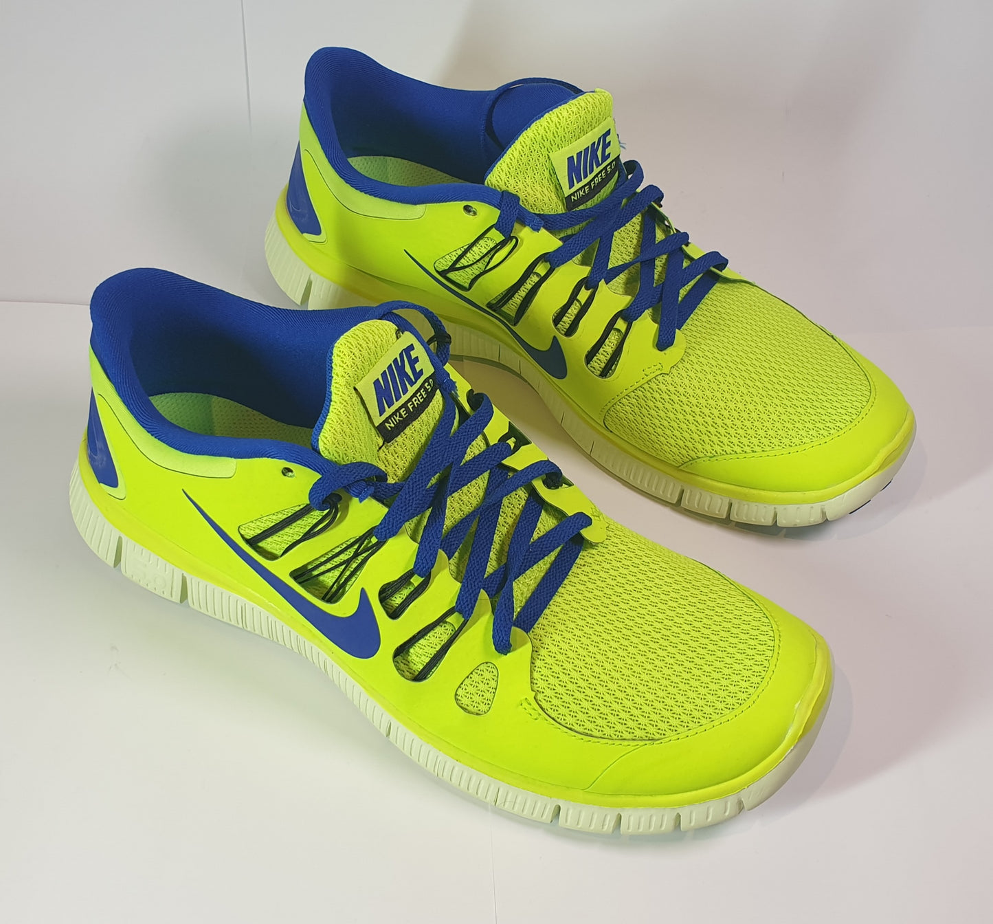 Nike Free 5.0+ running shoes in a volt (neon yellow/green) and blue