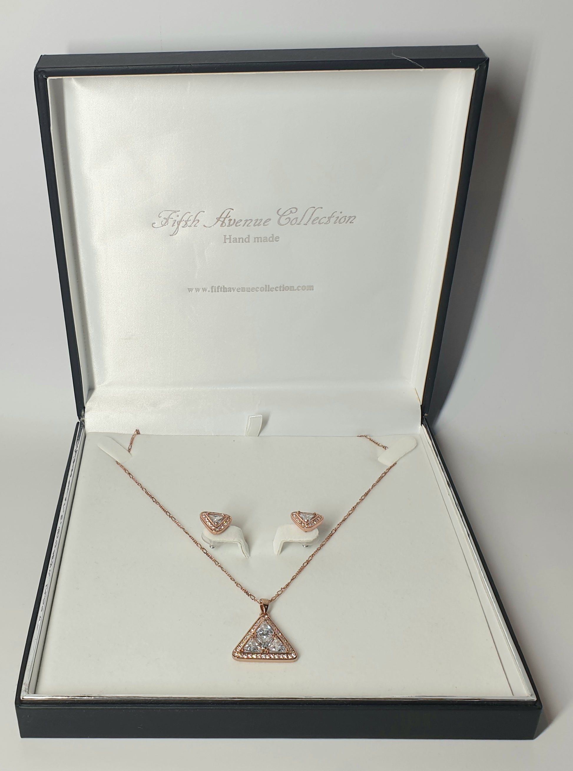 Rose gold necklace and earrings set in a Fifth Avenue Collection box.