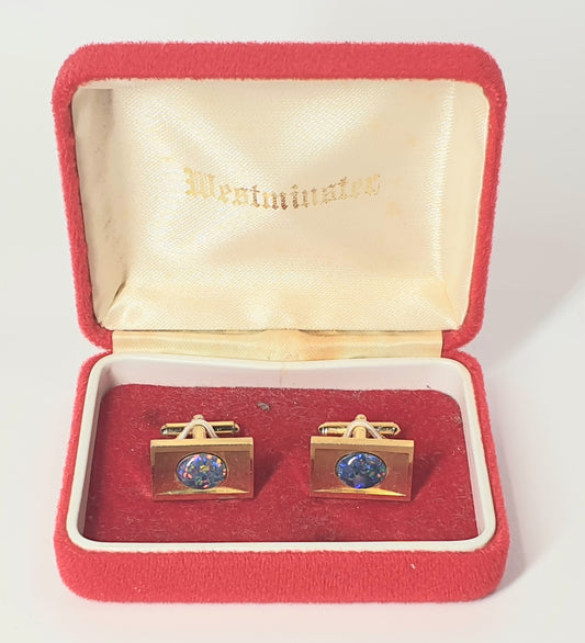 Gold cufflinks with blue gemstones in a red box with 'Westminster' branding.