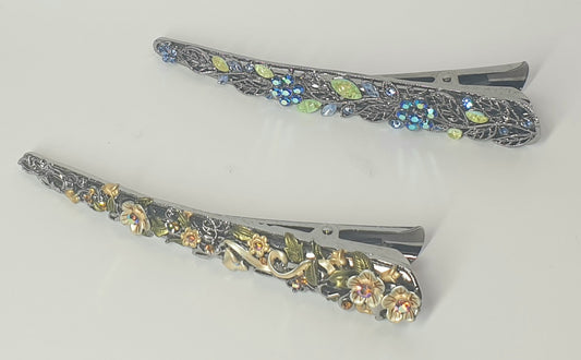Two decorative hair clips with floral patterns on a light gray background