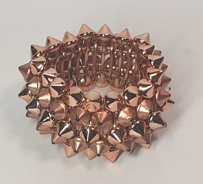 Rose gold spiked bracelet on a light gray background