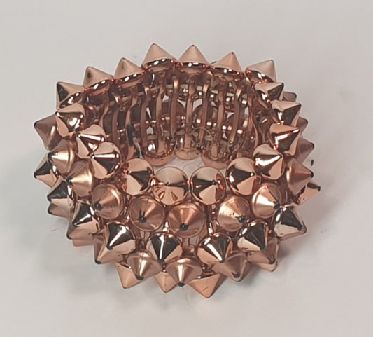 Rose gold spiked bracelet on a light gray background