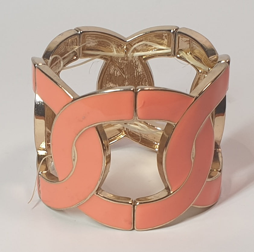 Coral bracelet with gold accents on a light gray background