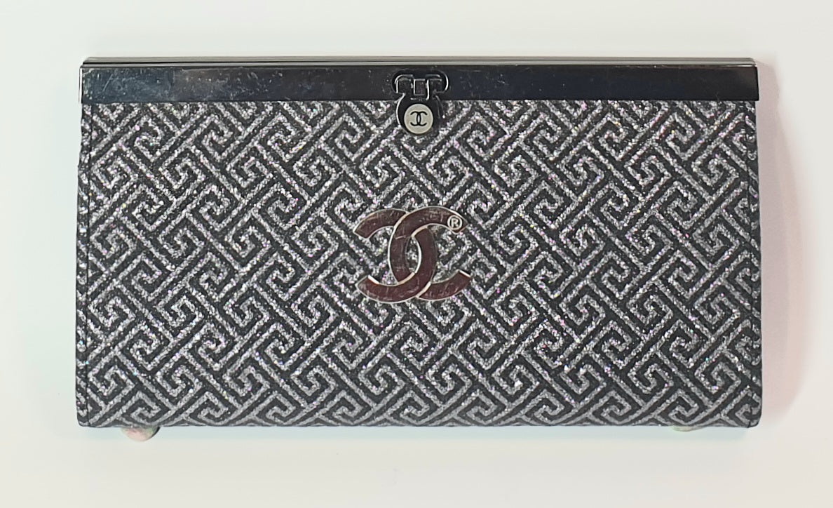 Chanel wallet with geometric pattern and logo on a white background