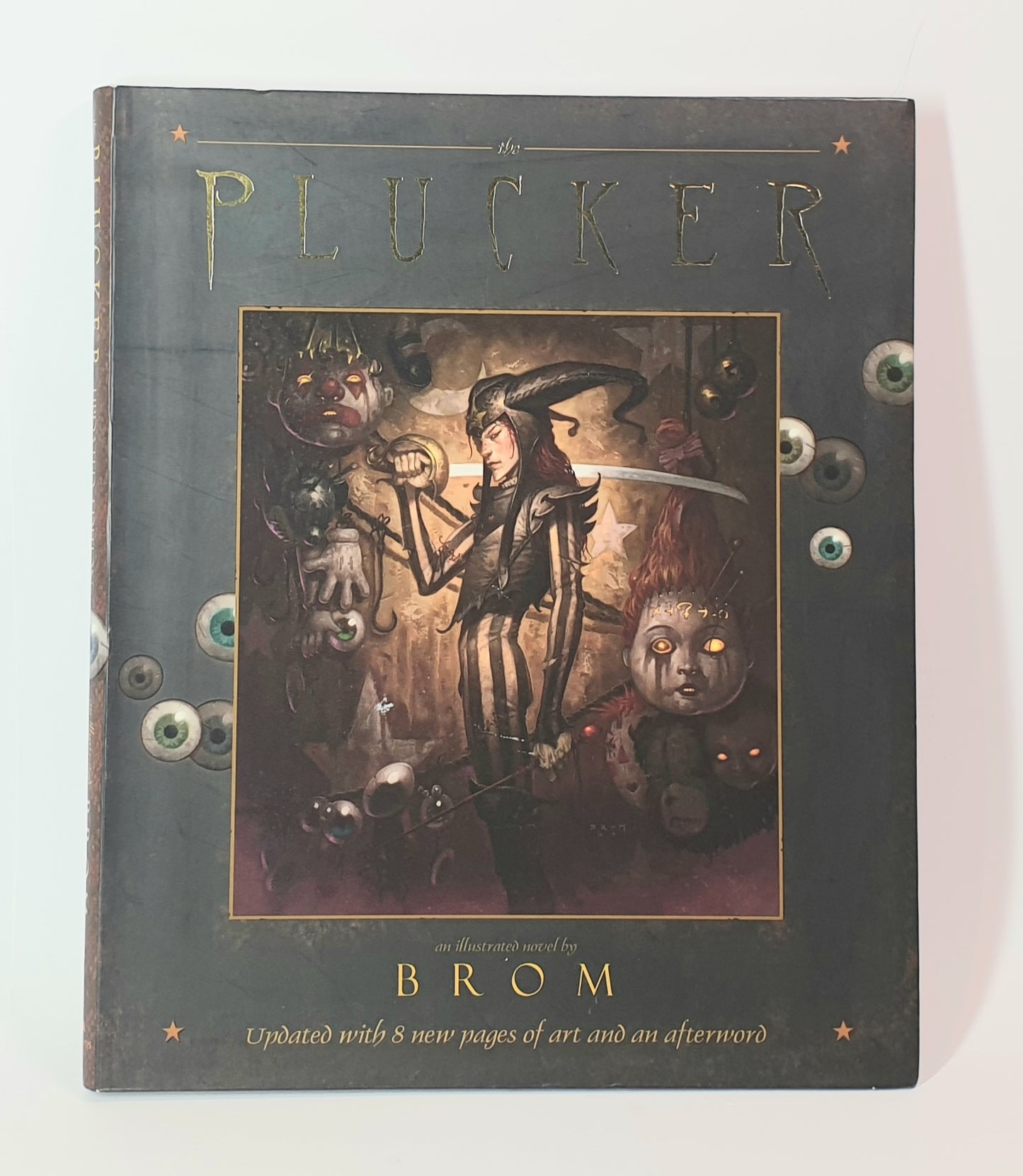 Book titled 'The Plucker' by Brom with illustrated cover on a white background