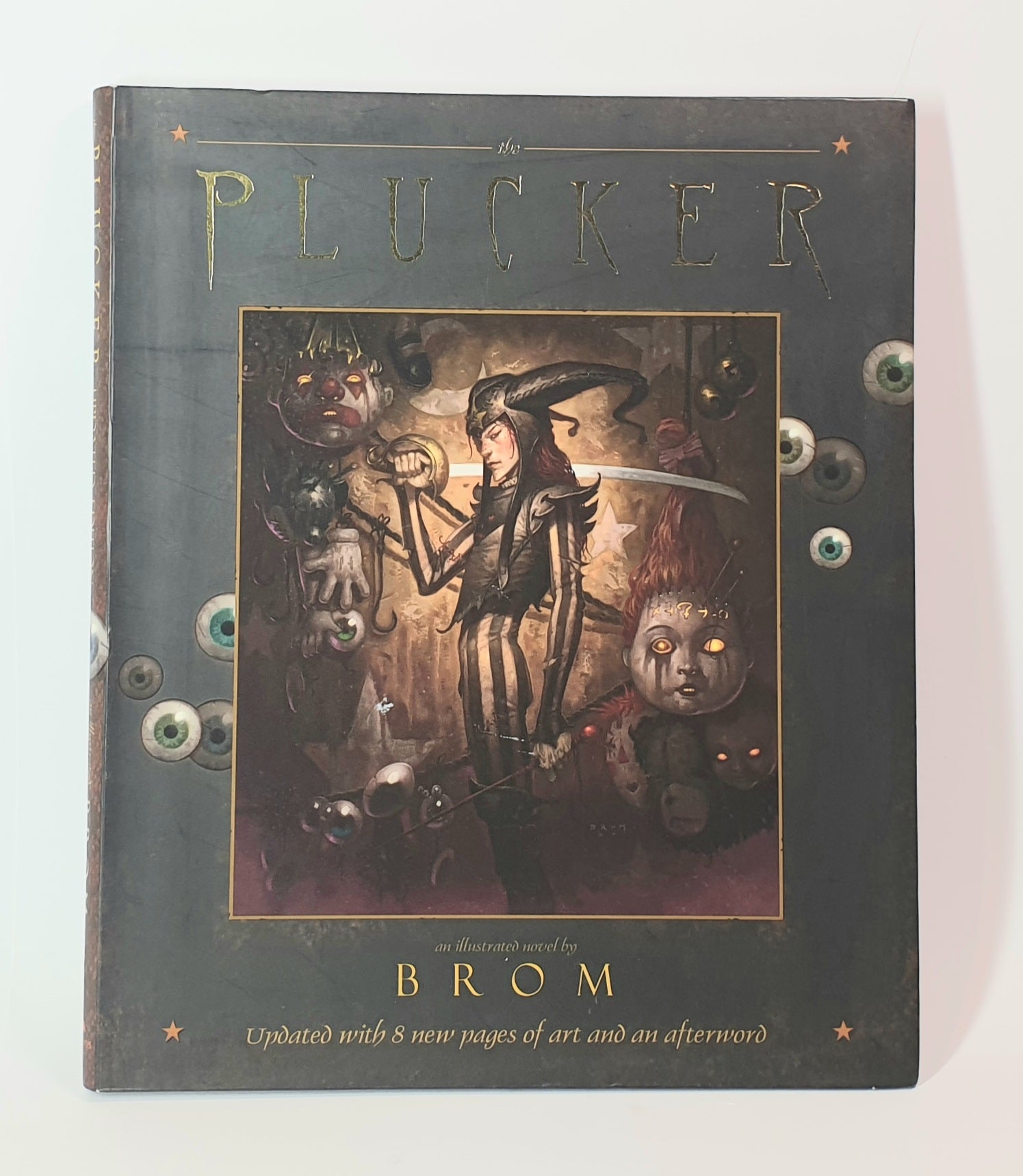 Book titled 'The Plucker' by Brom with illustrated cover on a white background