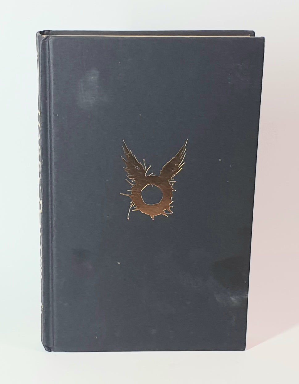 The Dark blue book of Harry Potter with a gold emblem on a white background