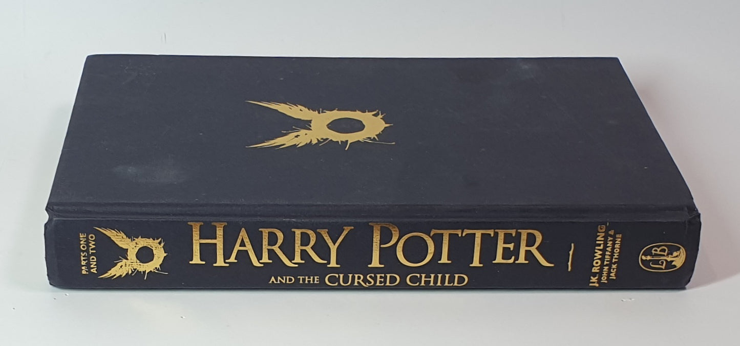 Book titled 'Harry Potter and the Cursed Child' with gold text on a black cover.