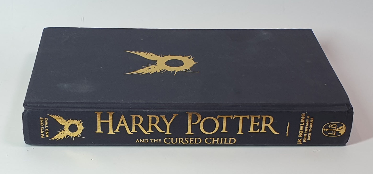 Book titled 'Harry Potter and the Cursed Child' with gold text on a black cover.