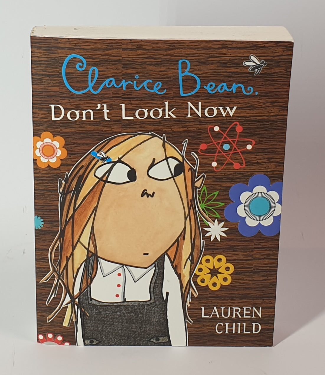 Book cover of 'Don't Look Now' by Clarice Bean with a stylized illustration of a girl on a wooden-textured background.