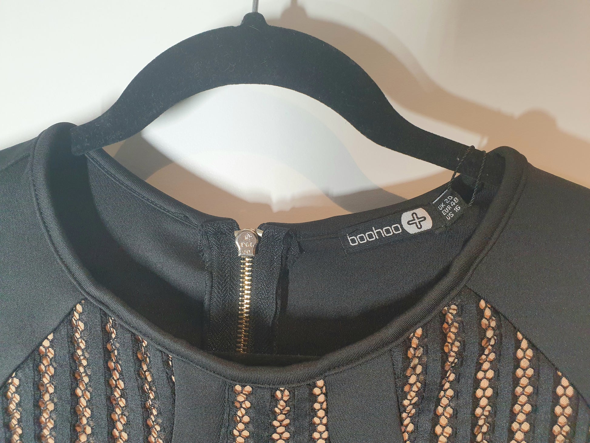Black jacket with decorative patterns on a hanger, featuring the Boohoo brand.