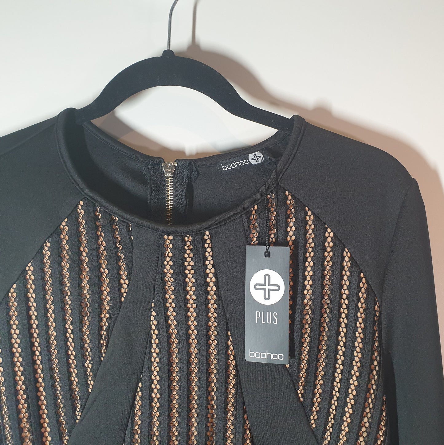 Black dress with brown geometric pattern on a hanger, featuring a brand tag. boo hoo