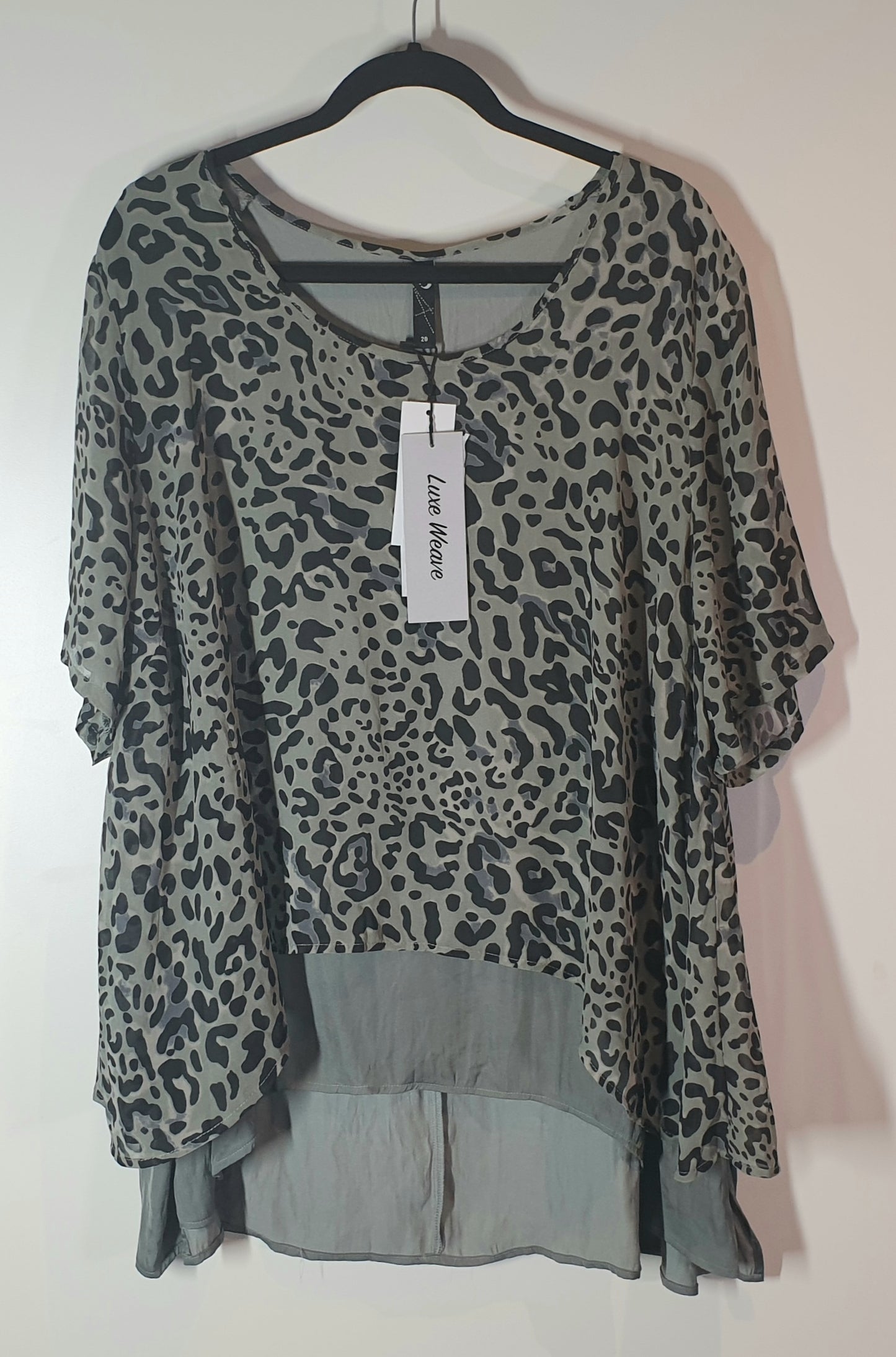Leopard print top on a hanger with a visible brand tag against a white background