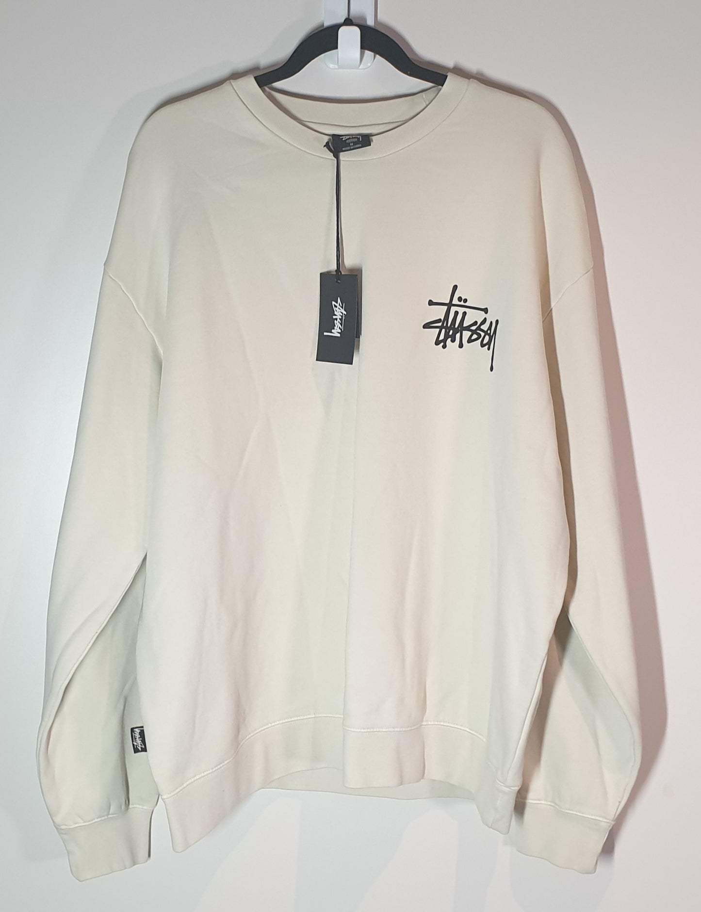 Stussy Beige sweatshirt with a brand tag on a white background