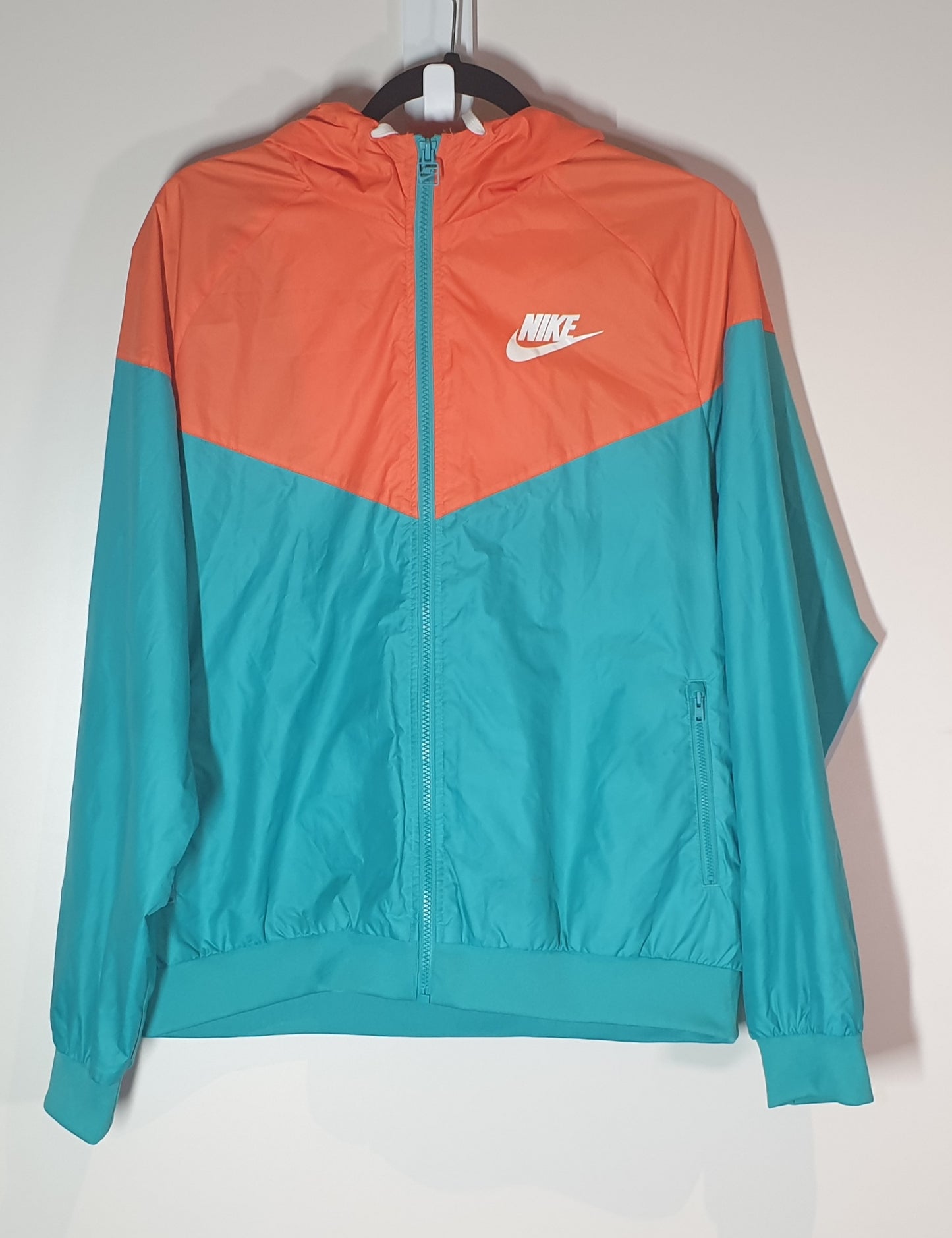 Two-tone orange and teal jacket with Nike logo on a white background