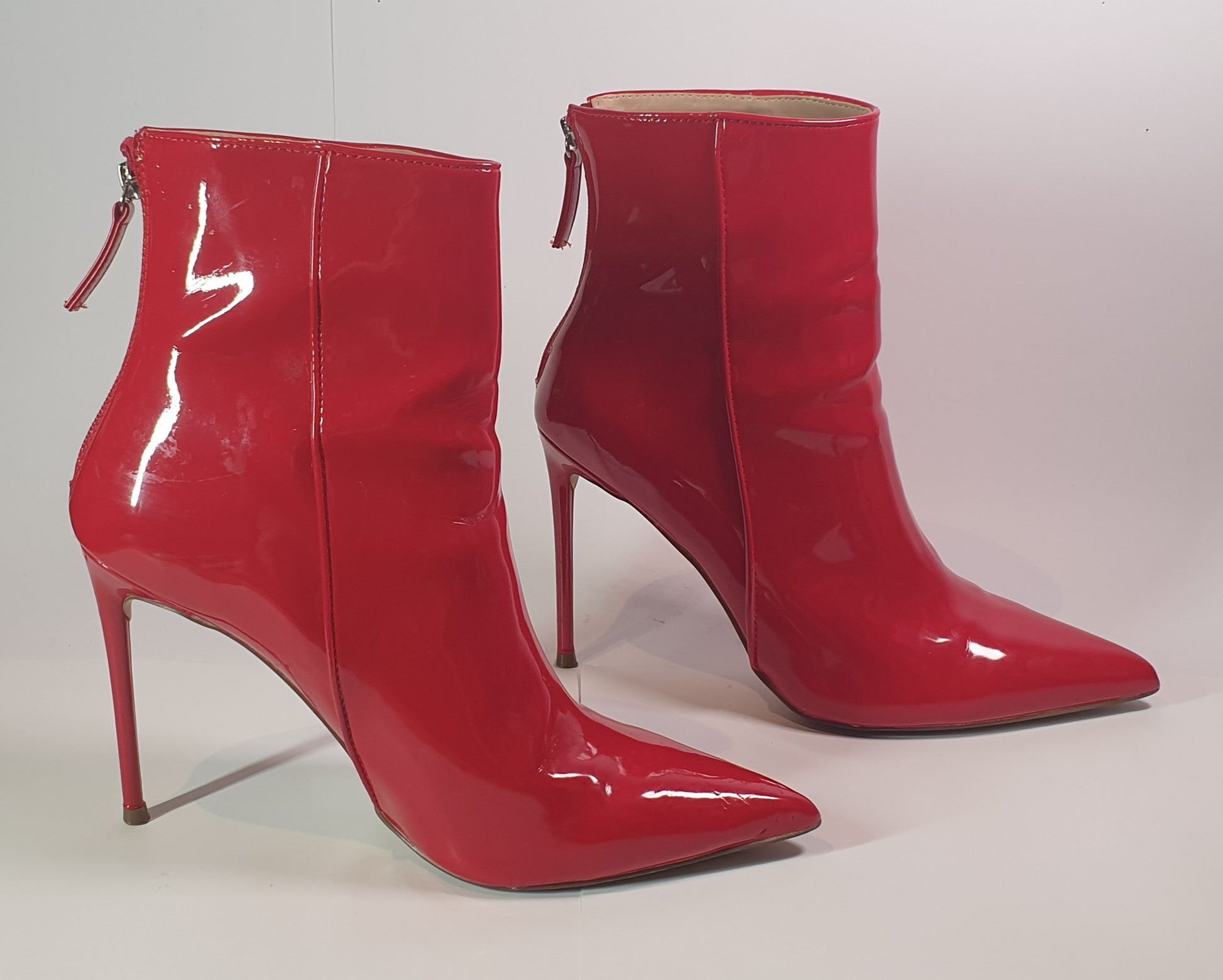 Pair of red high-heeled ankle boots on a white background