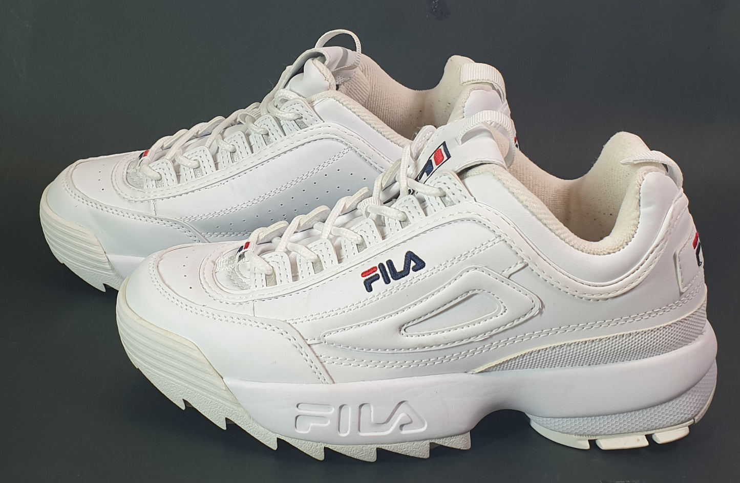 White Fila sneakers on a dark background