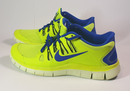 Pair of neon green and blue running shoes on a white background