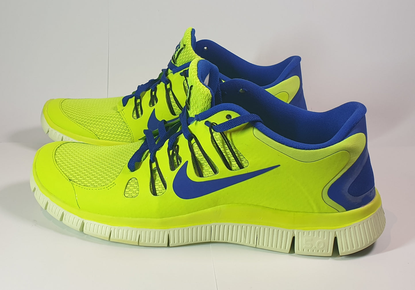 Nike Free 5.0+ running shoes in a volt (neon yellow/green) and blue