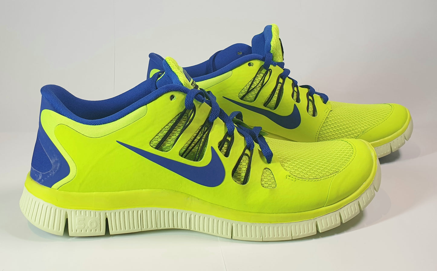 Nike Free 5.0+ running shoes in a volt (neon yellow/green) and blue