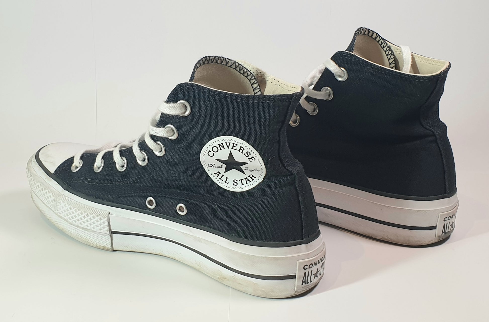 Pair of navy blue Converse All Star high-top sneakers on a white background