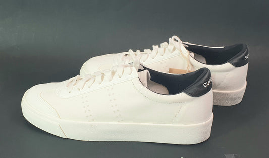White sneakers with black accents on a dark gray background