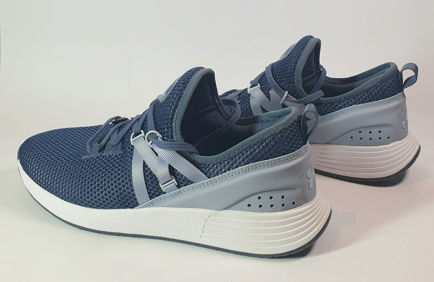 Blue athletic shoes with white soles on a light gray background