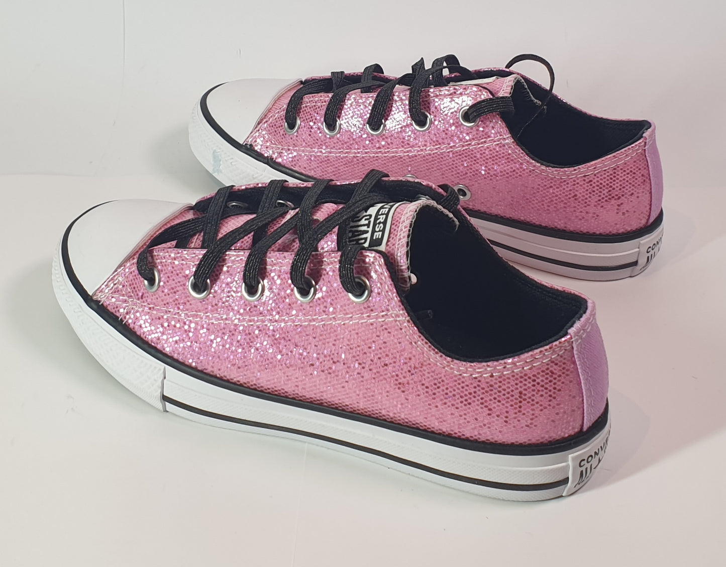 Converse Chuck Taylor All Star low-top sneakers in pink glitter with black laces. Kids