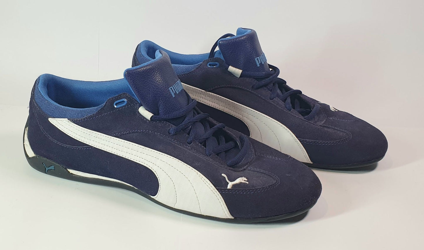 Pair of blue and white Puma sneakers on a light gray background
