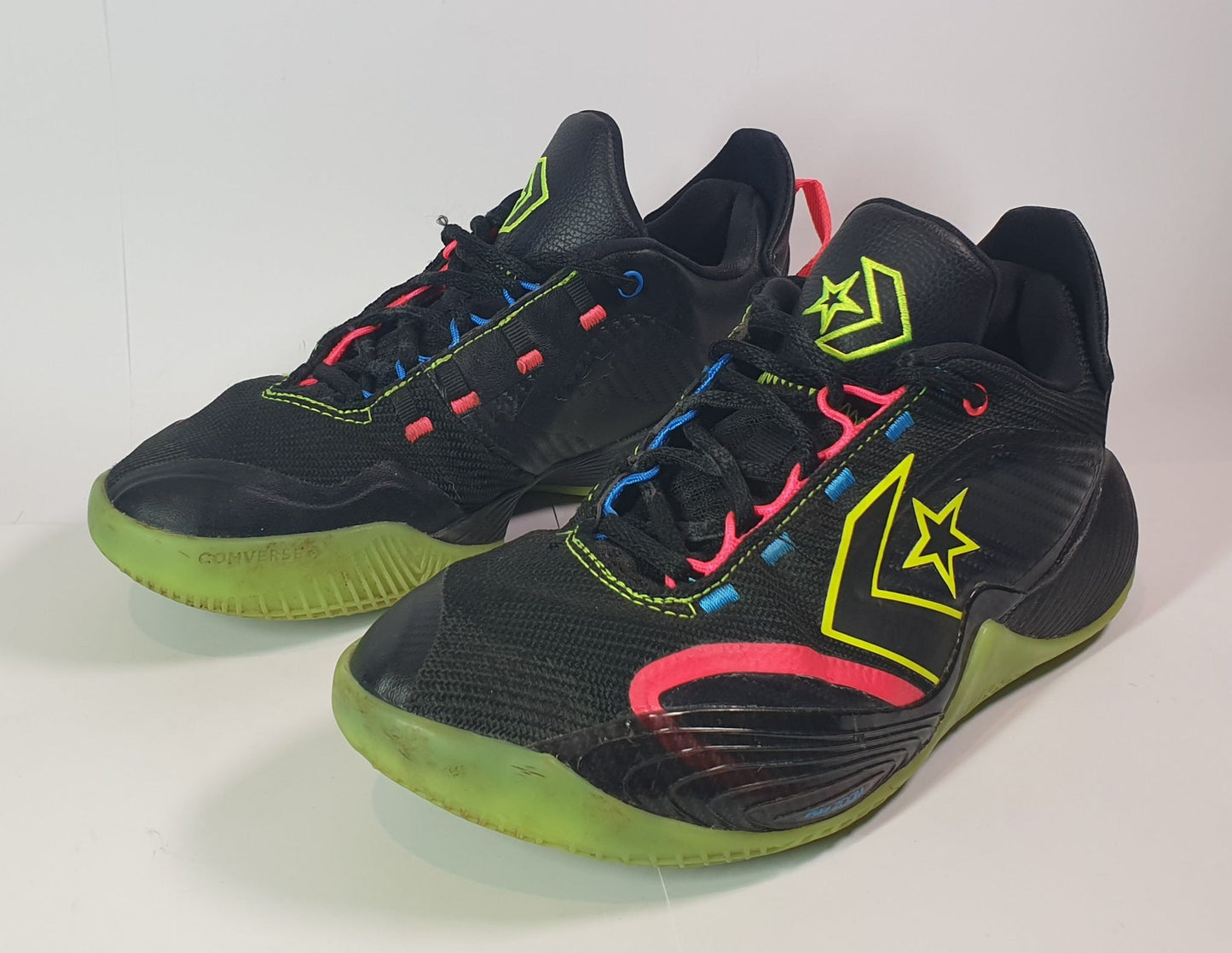 Black and green athletic shoes with colorful accents on a white background
