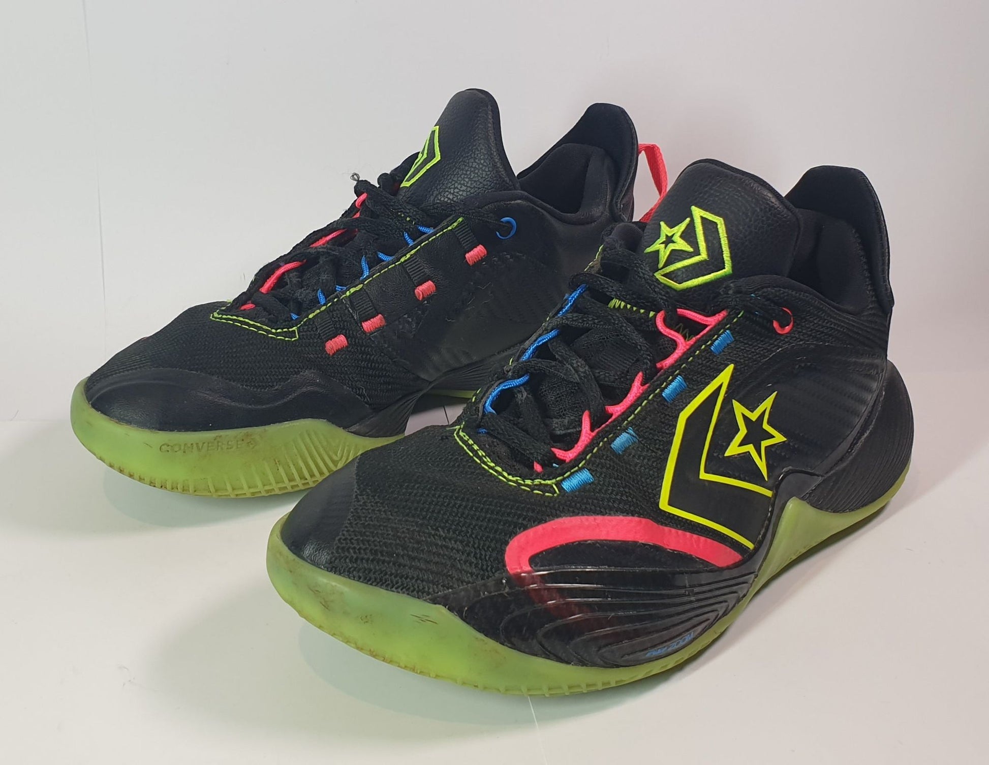 Black and green athletic shoes with colorful accents on a white background