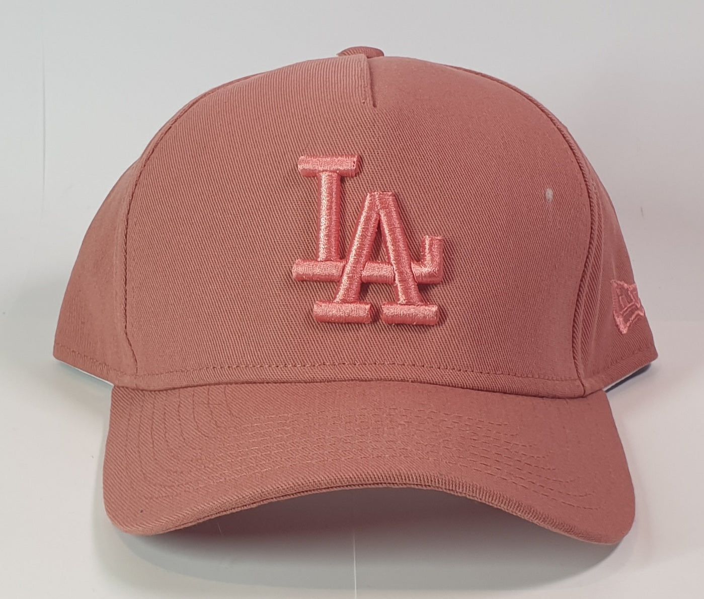Pink baseball cap with 'LA' logo on a white background
