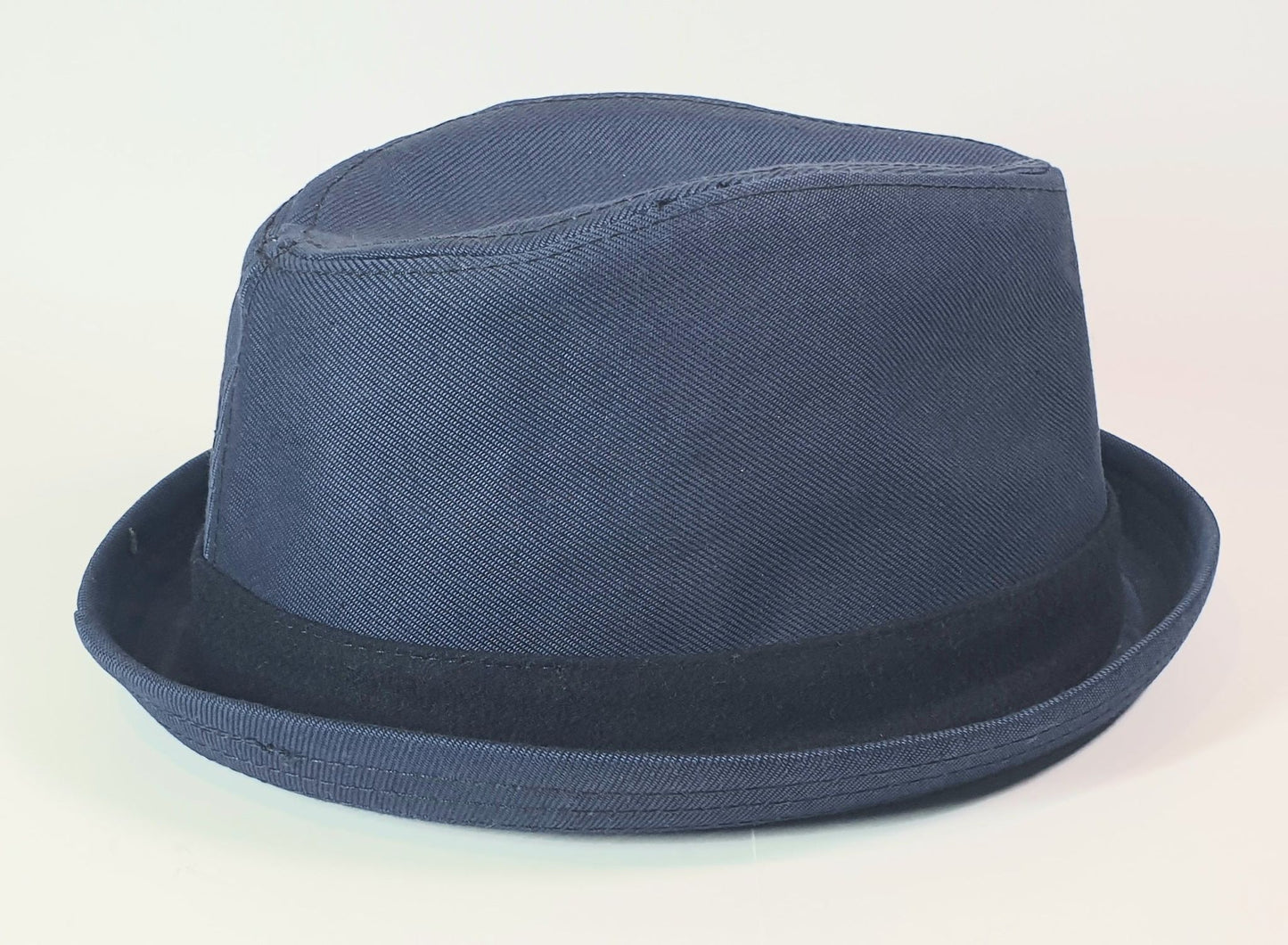 Navy blue fedora hat on a light gray background