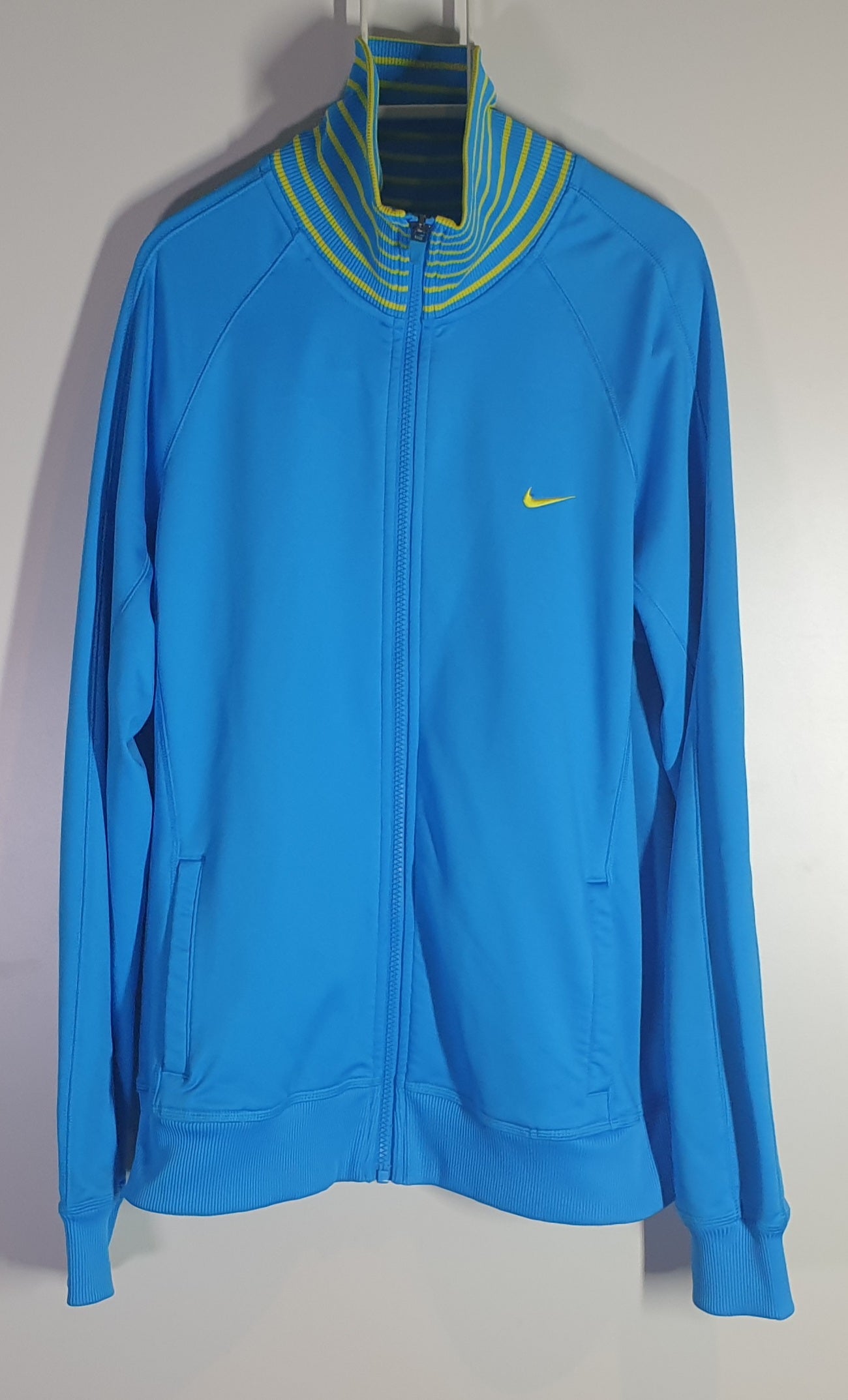 Blue jacket with a yellow Nike logo on a gray background