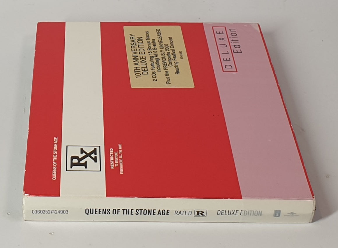 Red and white album cover with 'Queens of the Stone Age' text on a gray background, DELUXE EDITION
