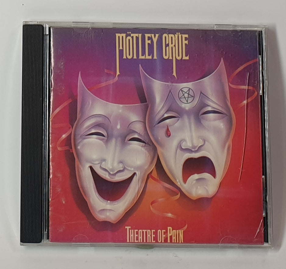 CD cover of 'Theatre of Pain' by Mötley Crüe with two theatrical masks on a red background.