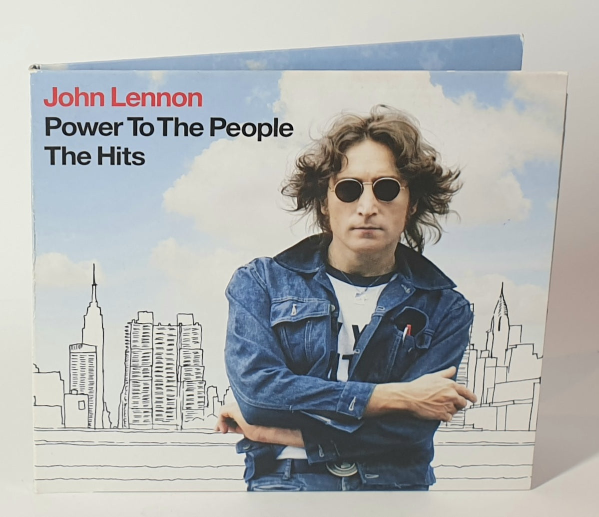 Vinyl record cover with John Lennon and cityscape, featuring the text 'John Lennon Power To The People The Hits'.