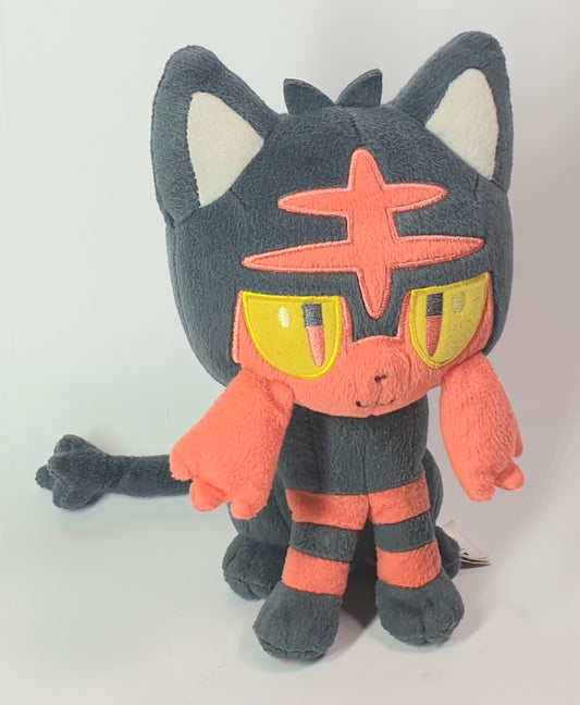 Plush toy with a dark gray body, orange face, and yellow eyes on a white background