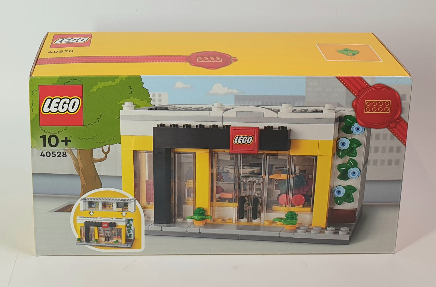 LEGO store box with yellow facade and LEGO logo on a white background