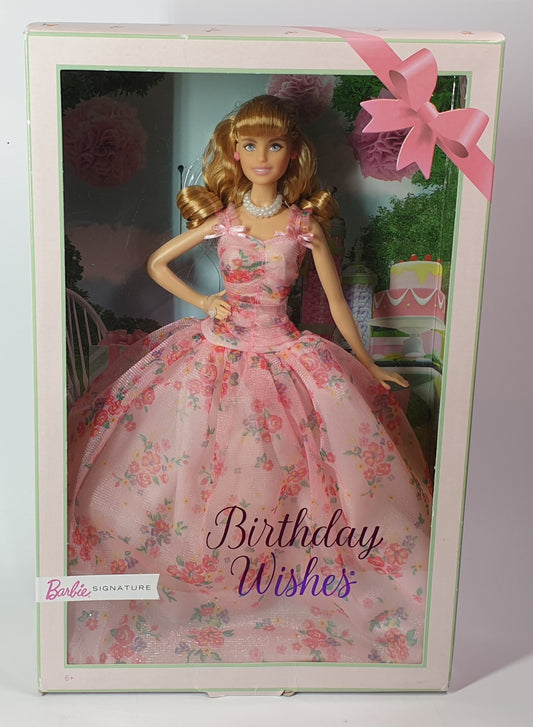 Barbie doll in a pink floral dress with 'Birthday Wishes' text in a decorative box.