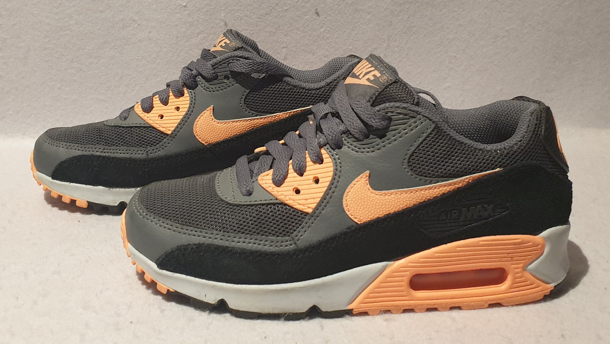 A pair of Nike Air Max running shoes in gray and orange colors, size US 6.
